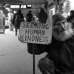 man with kindness sign